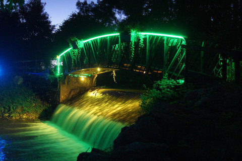 Un pont éclairé par des lumières colorées lors d'une manifestion son et lumière