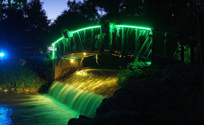 Un pont éclairé par des lumières colorées lors d'une manifestion son et lumière