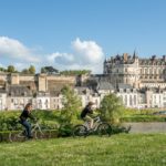 Des cyclistes circulent au bord de la Loire à Amboise en face du château