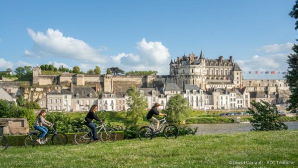 Des cyclistes circulent au bord de la Loire à Amboise en face du château