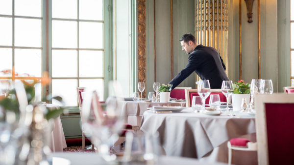 Dans un restaurant un serveur dresse une table